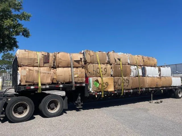 Cardboard bales strapped onto a flatbed trailer